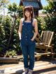 A woman in a denim jumpsuit posing for a picture.