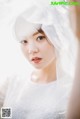 A woman in a wedding dress with a veil over her head.