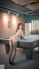 A woman in stockings and stockings playing pool.