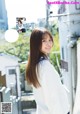 A woman in a white sweater is posing for a magazine.