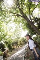 A woman in a school uniform standing on a bridge.